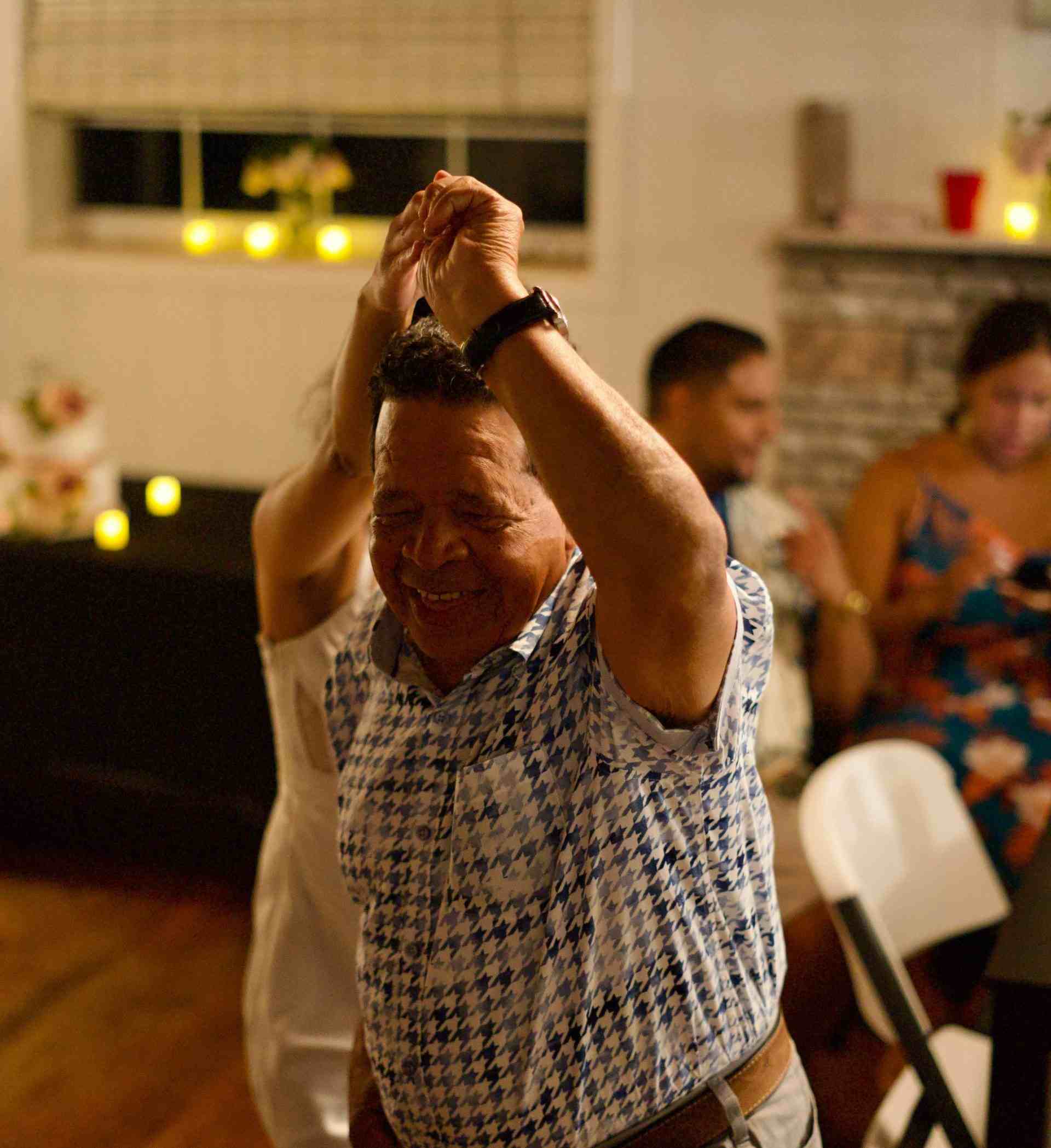 Mature man dancing happily at an indoor celebration, capturing the lively atmosphere.